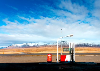 empty gas station near empty road facing snow capped mountain at daytime photo