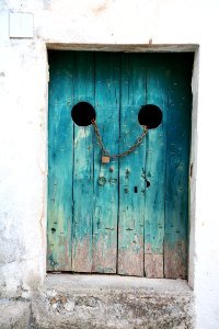 teal wooden door with gray chain and brown padlock photo