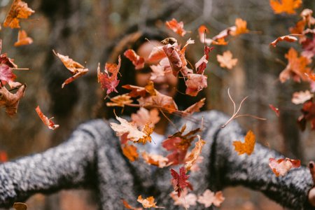 woman throwing maple leaves photo