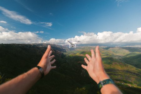 person pointing both hands on white drone during daytime photo