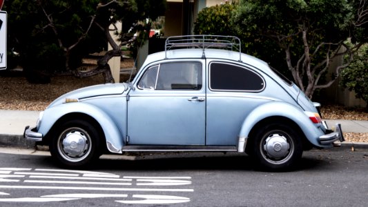blue Volkswagen Beetle on road photo