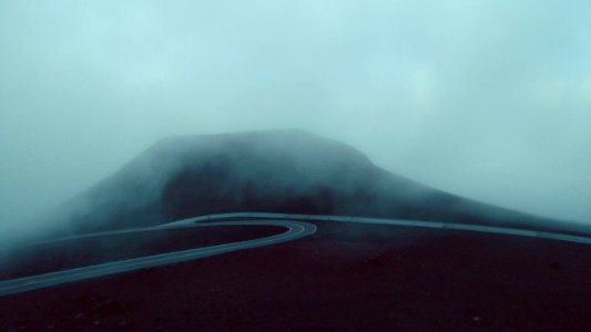 concrete road near mountain during foggy weather photo