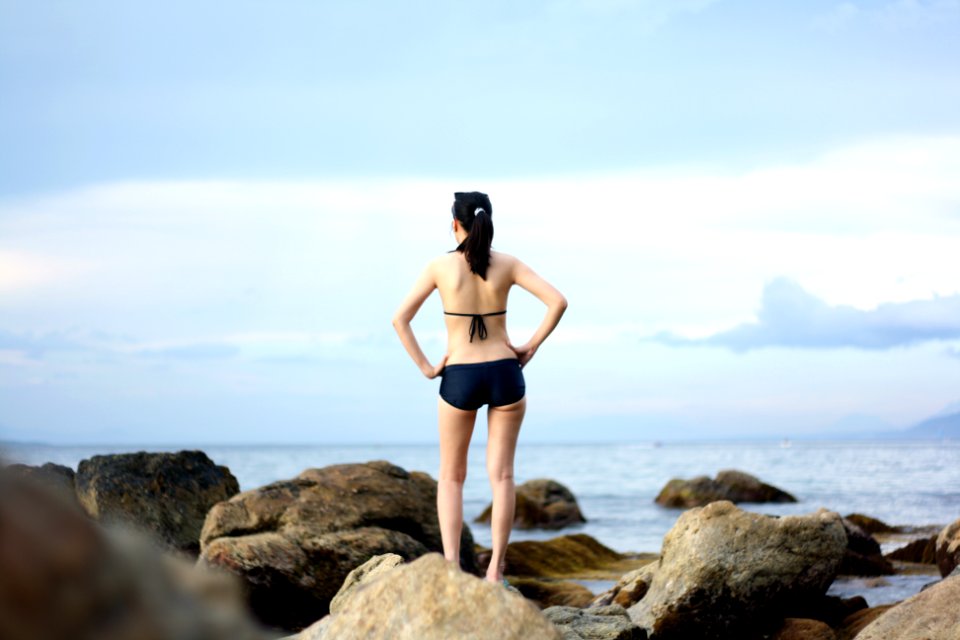 woman standing on stones near body of water photo