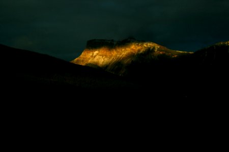 brown rock formations under nimbus clouds