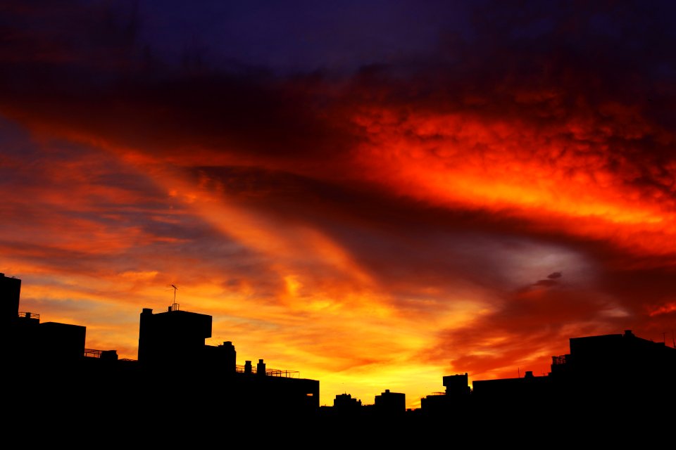 silhouette of buildings under scarlet sky