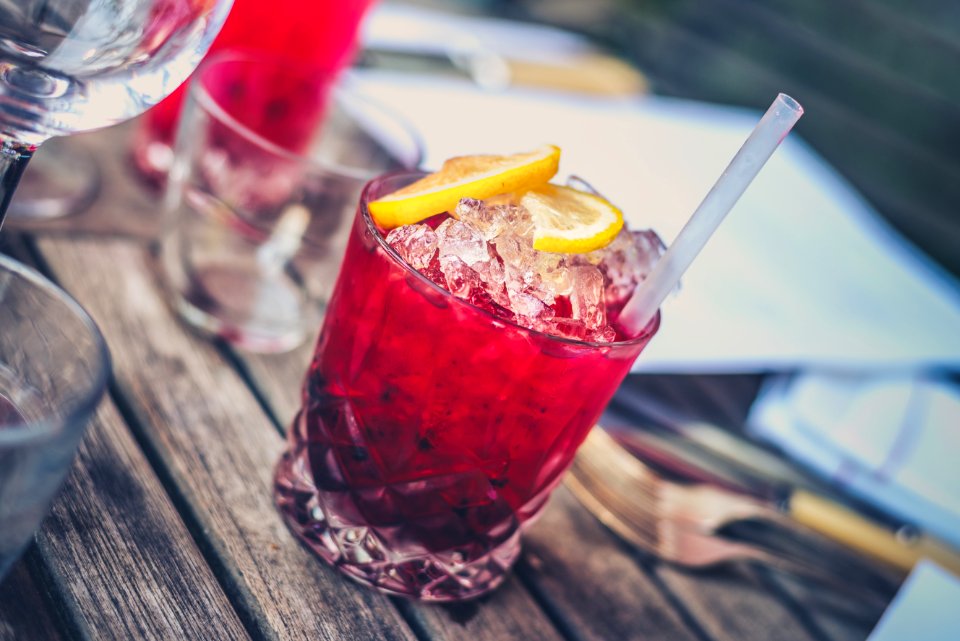 clear drinking glass with red wine and straw