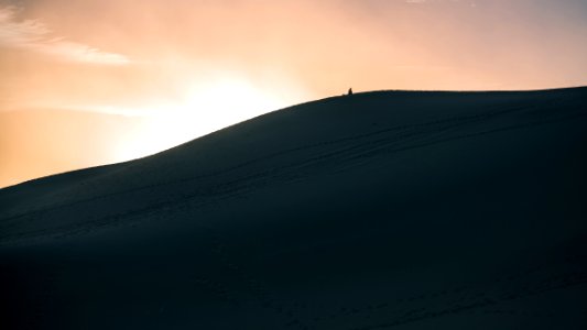 person walking in dune sand photo