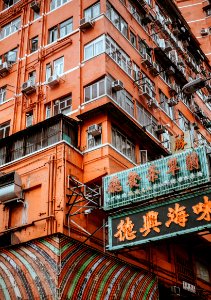 orange text with black background signage beside building structure photo