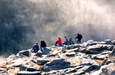 group of people sitting on gray rock
