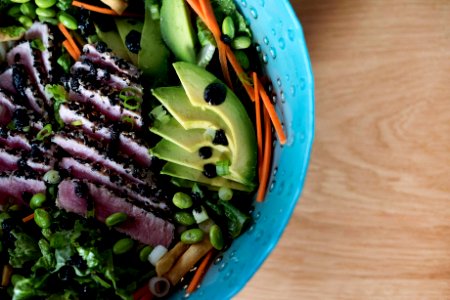 sliced cucumber and green vegetable in blue plastic bowl photo