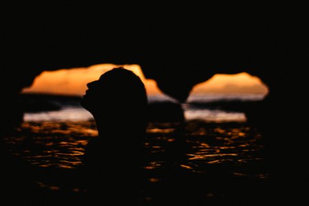 silhouette of woman inside cave photo