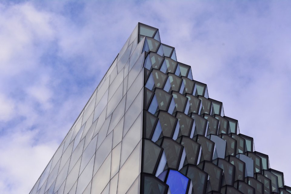 low angle photography of glass building under cloudy sky at daytime photo