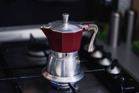 maroon and silver-colored kettle on stove photo