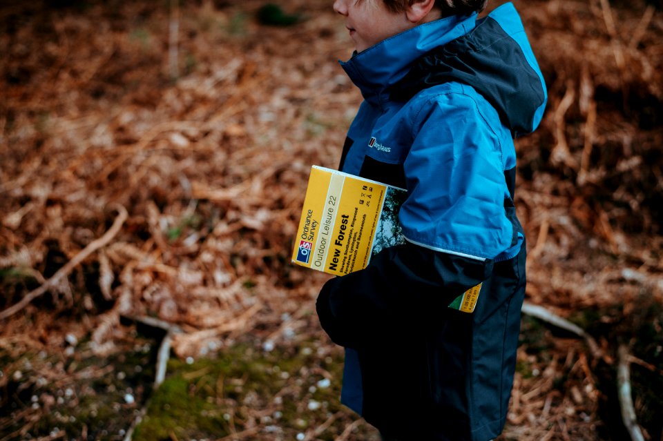 boy carrying book standing on ground during daytime photo