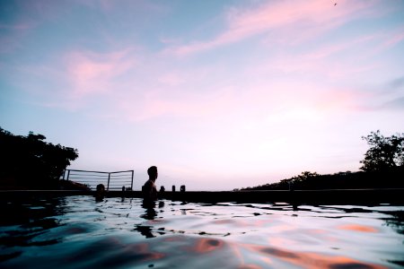 people swimming at pool under blue sky and white clouds during daytime photo