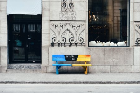 blue and brown wooden bench on sidewalk photo