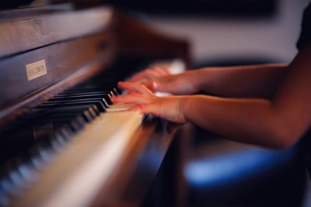 person playing upright piano photo