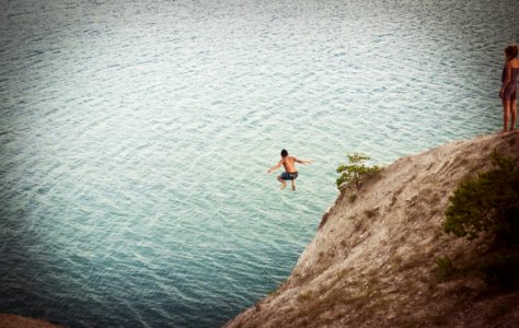 man jumping on body of water photo