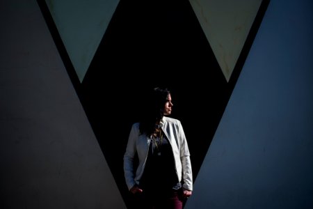 woman standing behind black wall while looking right side photo