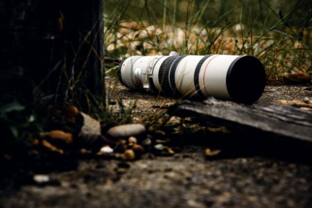 white and black camera lens on ground during daytime photo