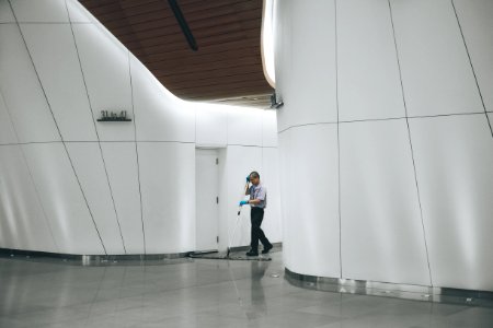 man cleaning on floor beside white wall photo