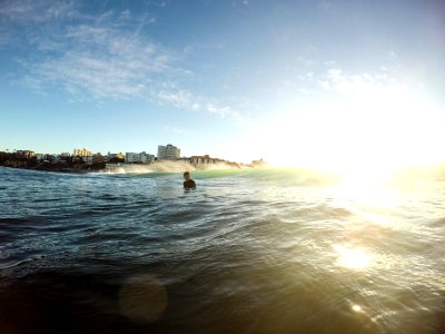 A boy standing at waist level in the ocean. photo