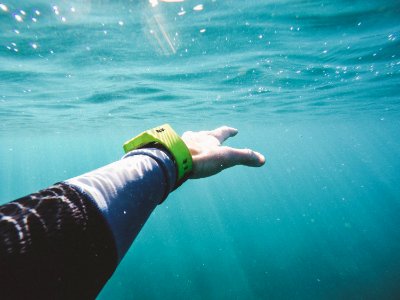 A person's hand reaching out underwater. photo
