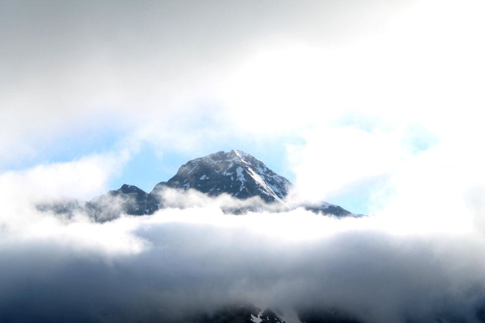 black mountain covered with white clouds