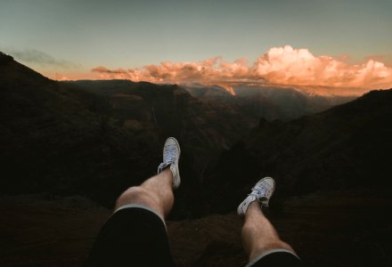 person sitting white facing cliff photo