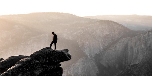 man standing on top of mountain during daytime photo