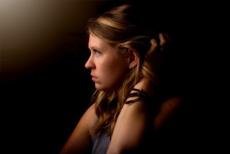 shallow focus photography of person holding her hair photo