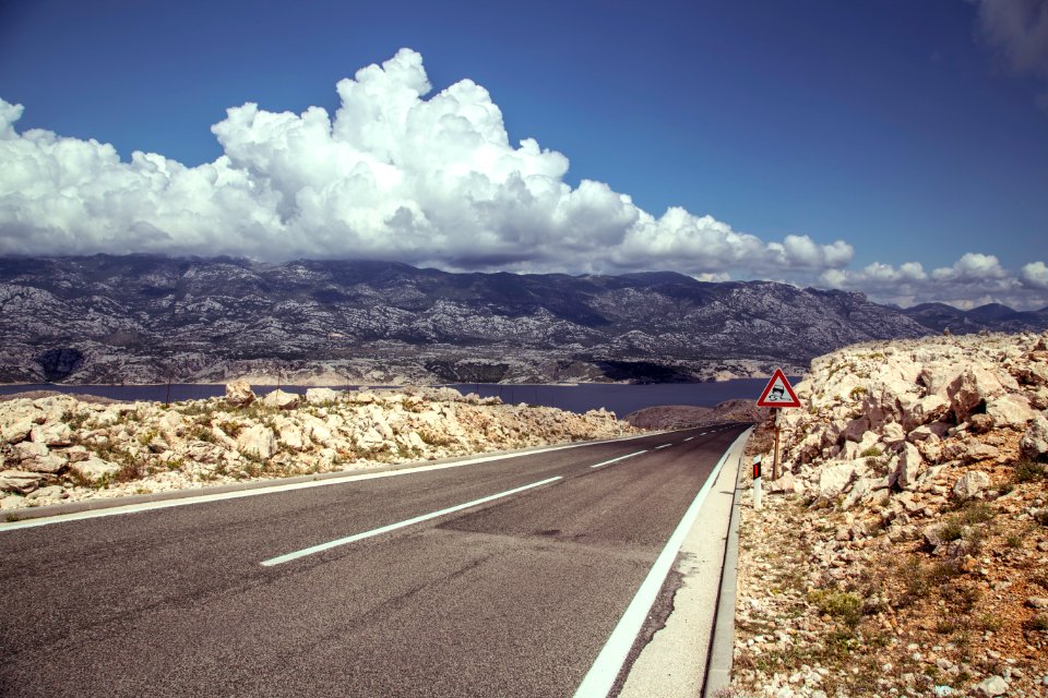 gray asphalt road under white clouds and blue sky during daytime