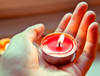person holding red and white candle photo