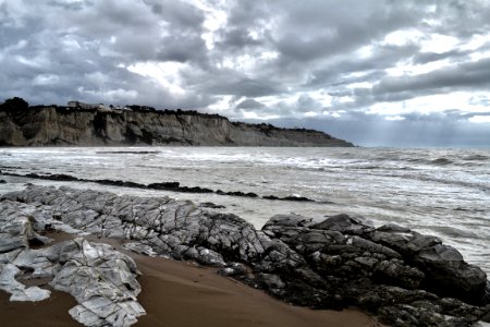 grey rocks near sea under grey sky photo
