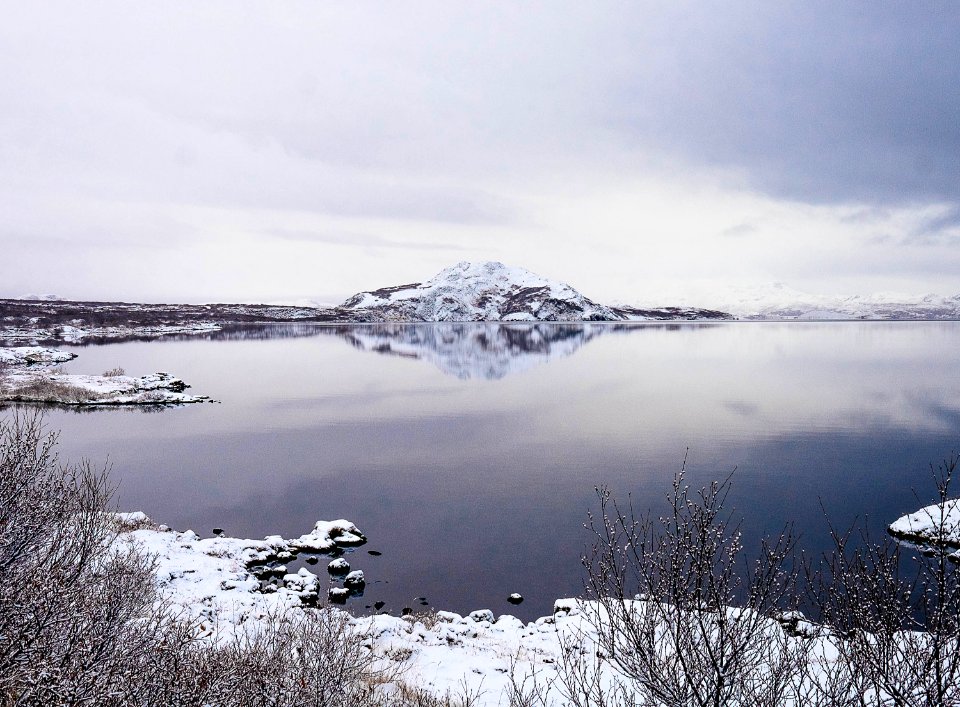 mountains covered with snow near lake