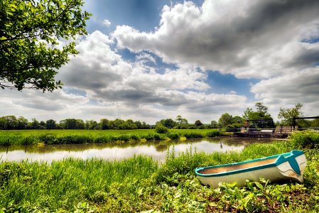 white and green boat on green grass field during daytime photo