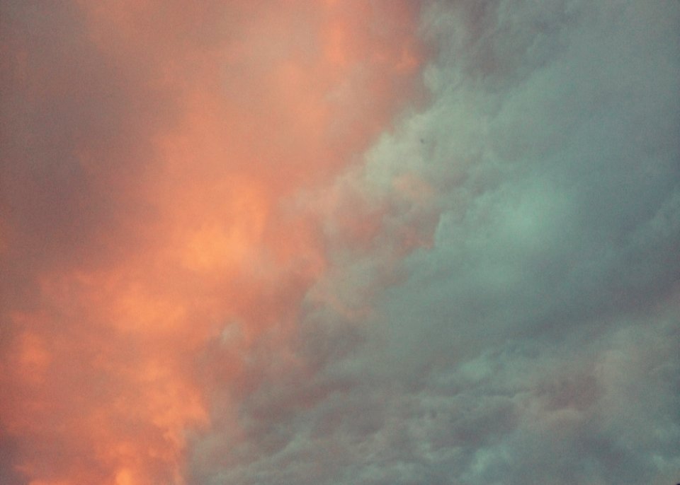 Orange and bluish green clouds in the sky.