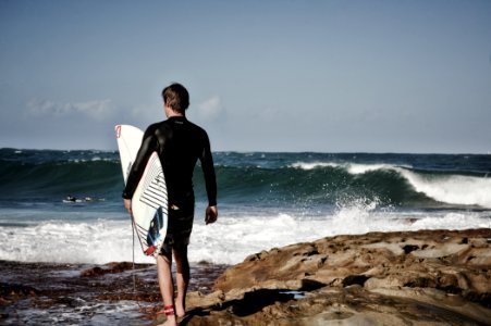 person holding surfboard near shore photo
