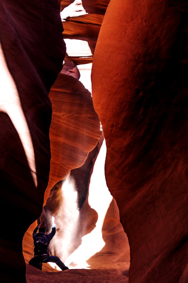 person in black pants standing on brown rock formation during daytime