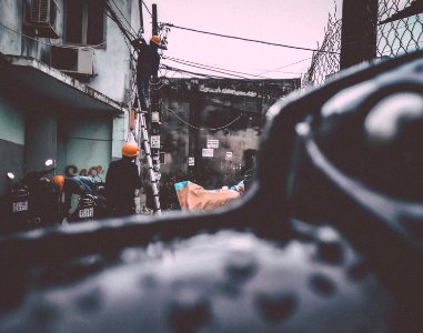 man wearing hard hat on ladder fixing post cable photo