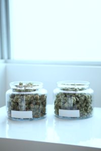 full of kush in clear glass jars on table photo