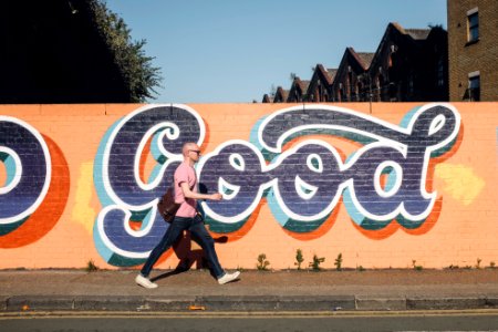 man walking beside graffiti wall photo