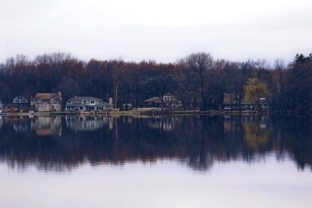 Cottages on the water in the middle of the woods, perfectly reflecting off the lake.