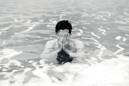 grayscale photo of man on body of water photo