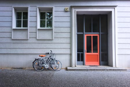 two assorted bicycles near orange door photo