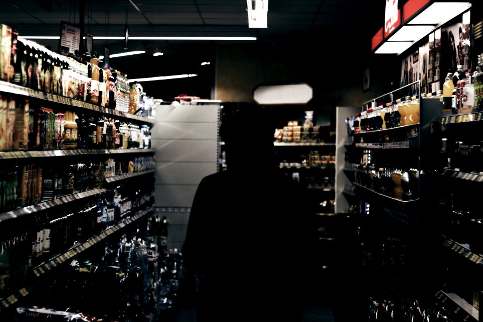 silhouette of person in store liquor section