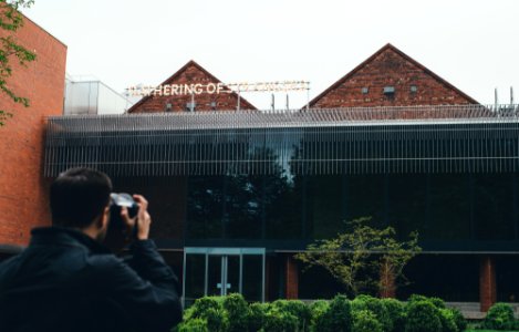 man taking picture to building photo