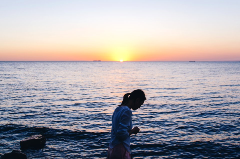 woman in blue long-sleeved shirt near body of water photo