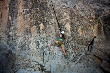 woman climbing on rock cliff during daytime photo