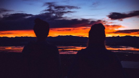 silhouette photo of two women starring at sunset photo